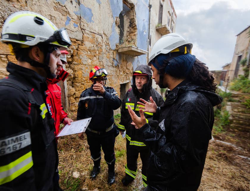 Structural Engineer discussing with his team the structural soundness of the building on site and wearing protective gears