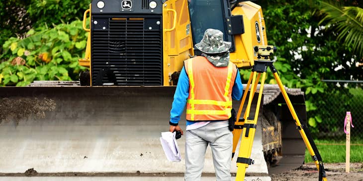 Surveyor getting ready to calculate dimensions on a construction site.