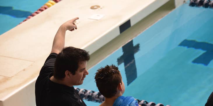 Swim instructors teaching a young student