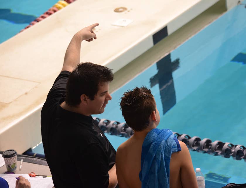 Swimming coach giving instructions to a young student