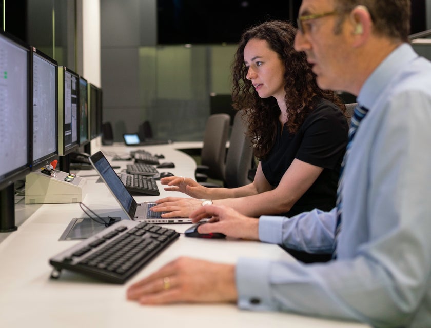 Systems analyst working with a colleague evaluating current IT systems while preparing for a software upgrade