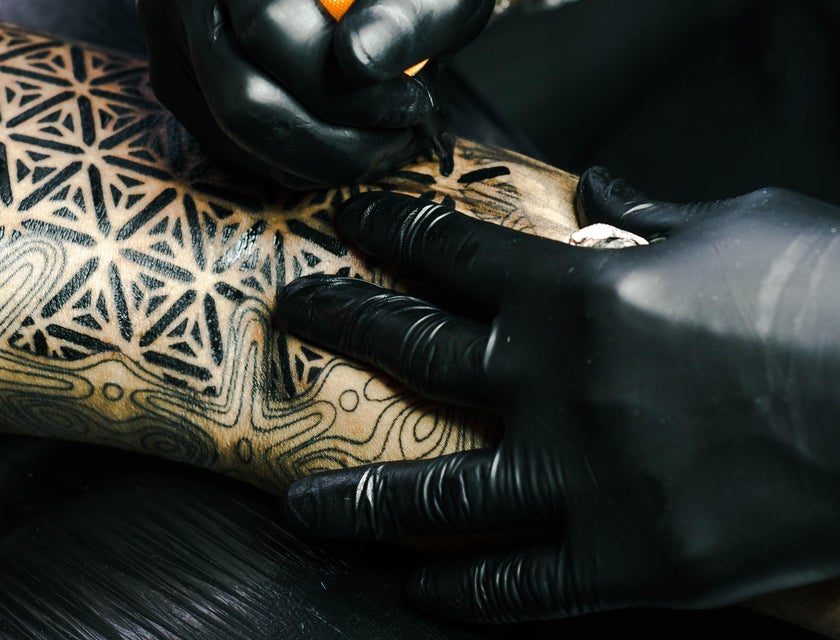 tattoo artist working on an arm piece