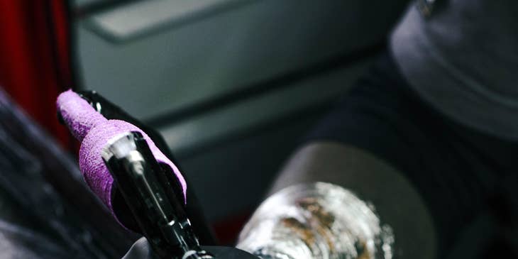 tattoo artist working on an arm piece