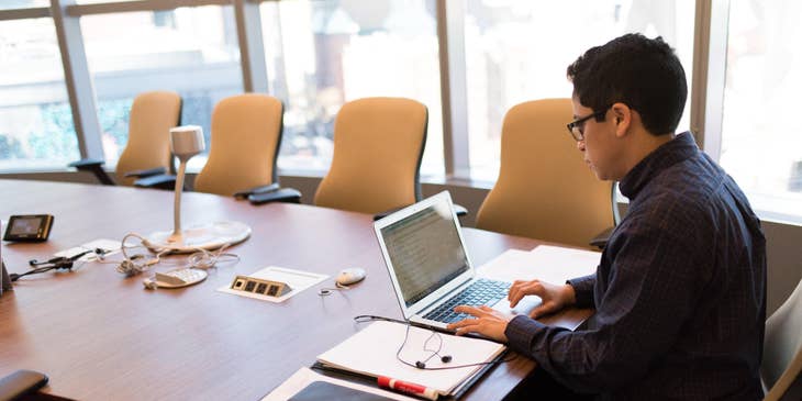 Tax preparer audits tax returns for clients while waiting for a meeting
