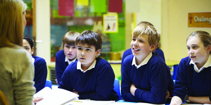 Teacher aide explains a new lesson to a chosen group of students