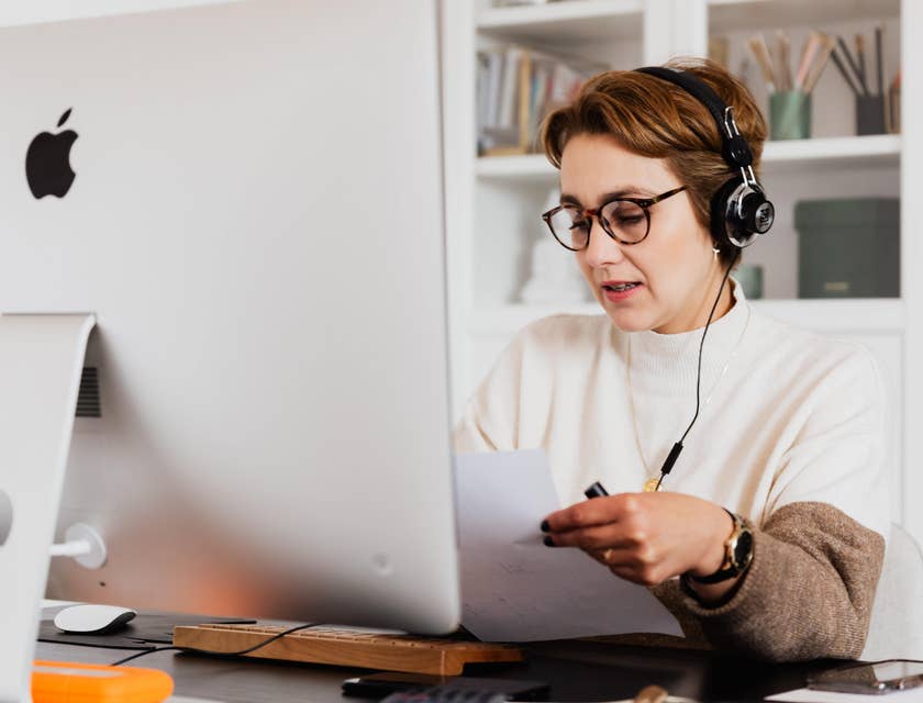 female technical account manager holding a white paper while talking to a client over the phone