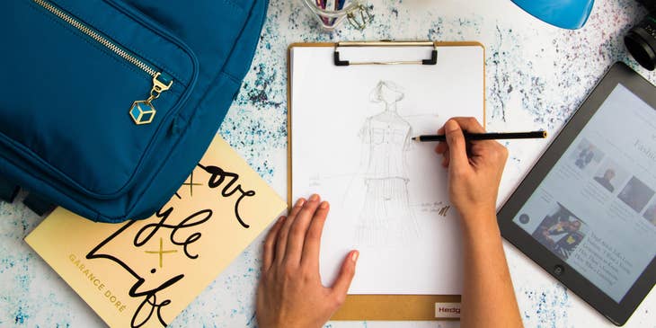Technical designer is working on a sketch on printer paper to meet the project deadline