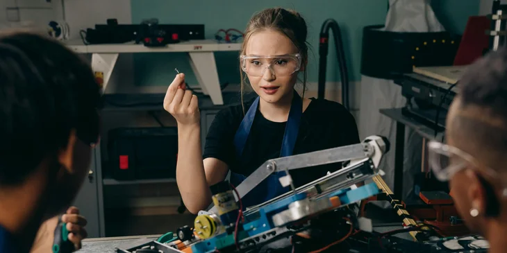 A female technical engineer showing the product's test results to her coworkers in a workshop.