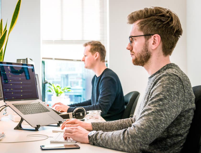 Technical manager checks the performance metrics of his team while working on a software update on his computer