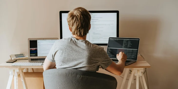 A technical program manager checks new software program on multiple computer.