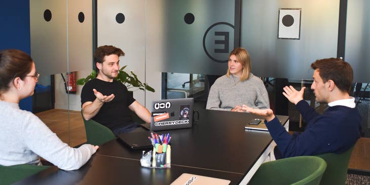 A group of co-workers discussing a project around a table.