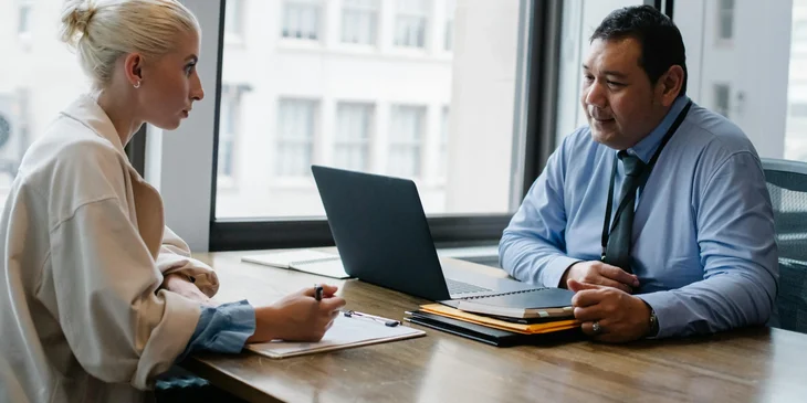 A technical sales executive in a meeting with a client advising of the best products for his company.