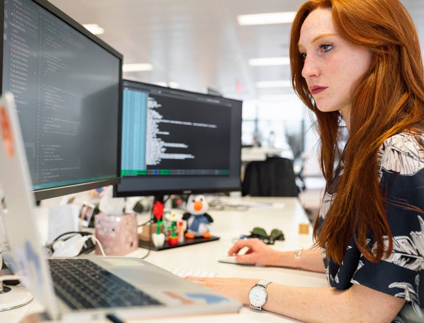 Test Automation Engineer developing an automation program on her workstation while sitting