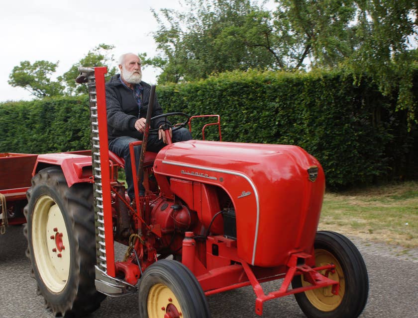 Tractor driver maneuvering towards the plantation to pick up the harvested crops