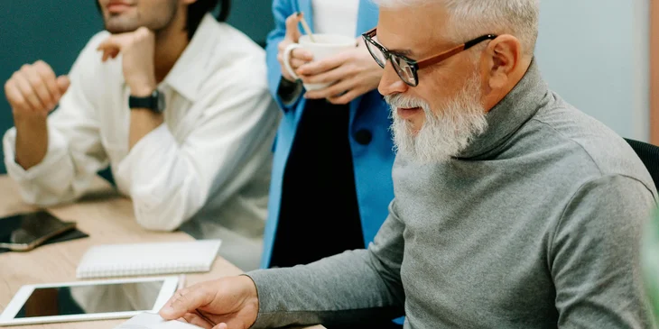 A training consultant checks updated learning materials during a meeting.