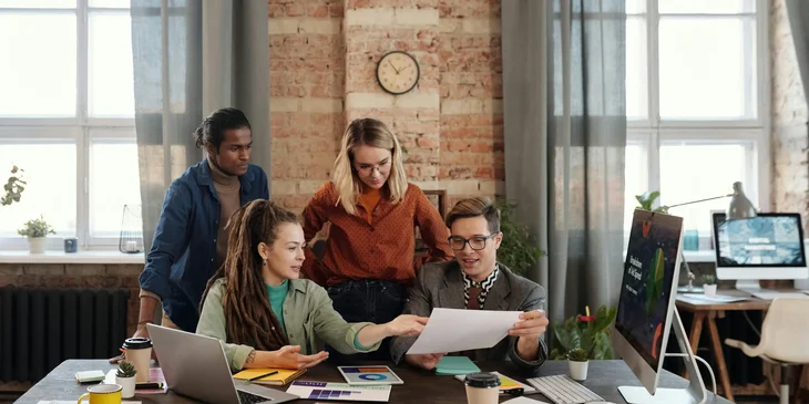 A vice president of sales coordinating with a marketing team for the new design prints of the new products for promotion.