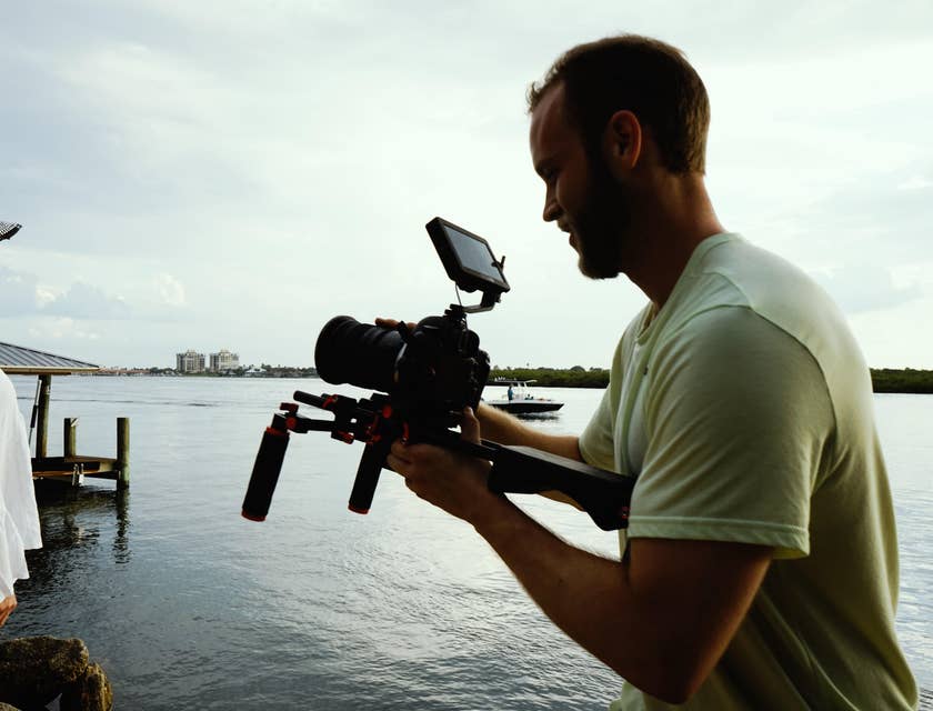 a couple on a lakeside being recorded by a videographer