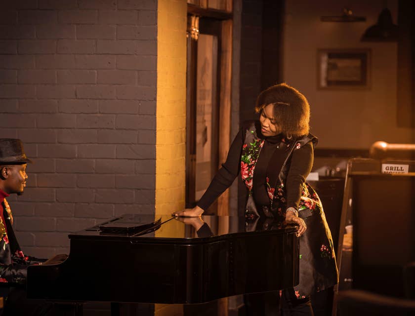 Vocal coach plays the piano as the singer prepares to sing for a concert
