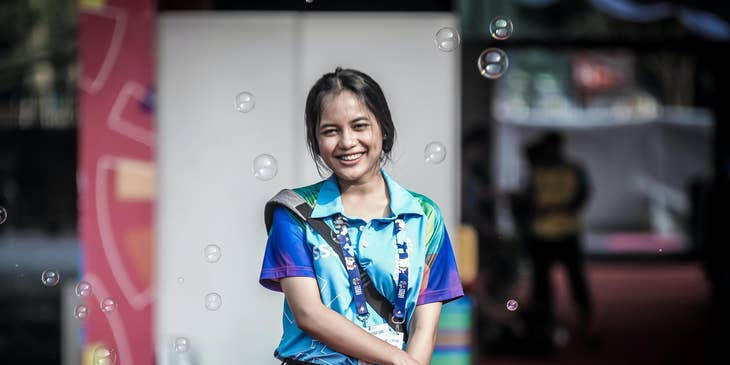 a smiling volunteer coordinator while holding a wireless handset while organizing the event