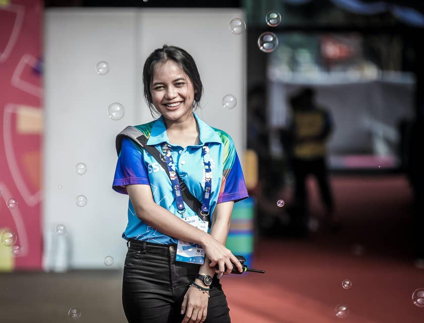 a smiling volunteer coordinator while holding a wireless handset while organizing the event
