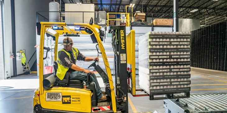 A warehouse worker using a forklift.