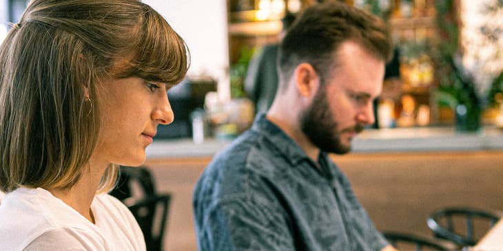 two web designers typing on laptops at web design firm