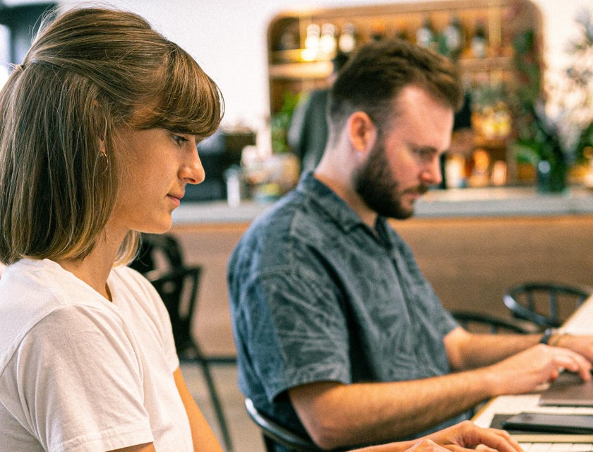 two web designers typing on laptops at web design firm