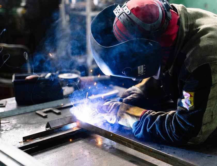 Welding engineer in full protective gear while working on a workshop