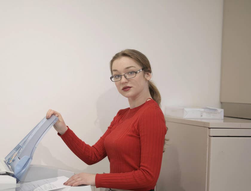 Woman using a printer in an office.