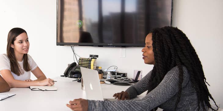 Woman sitting around a desk.