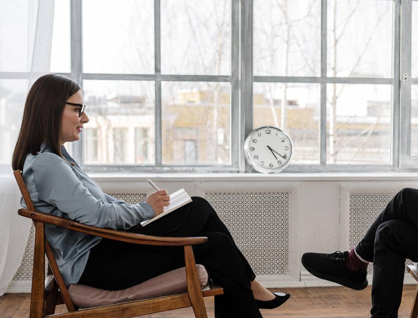 Two people sitting in chairs facing each other.
