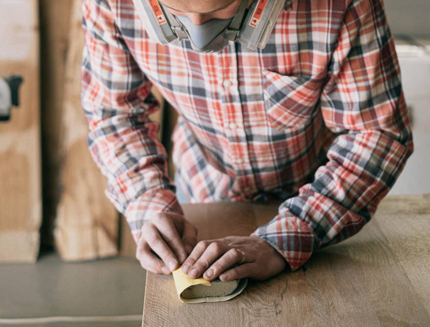 wood finisher sanding the item in preparation for finishing