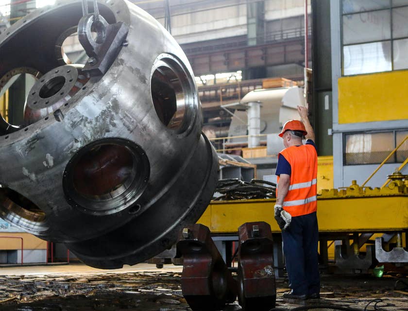 A yard hostler assisting a fellow colleague to load a material to be transported to a weighing platform.