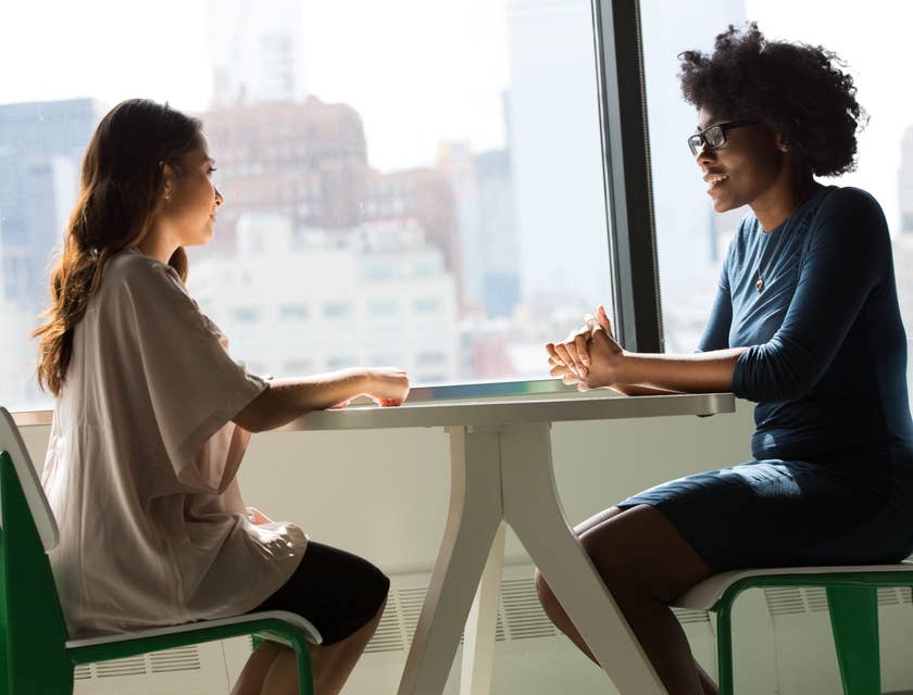 Youth specialist talking to her client while sitting on a white table