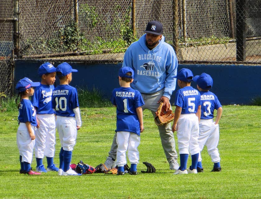 A man coaching a little league team.